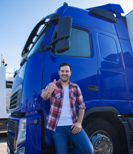 Professional truck driver in front of long transportation vehicle holding thumbs up ready for a new ride.